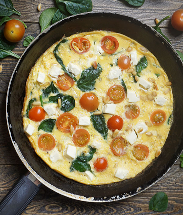 Omelet met spinazie, cherrytomaten, feta en pijnboompitten